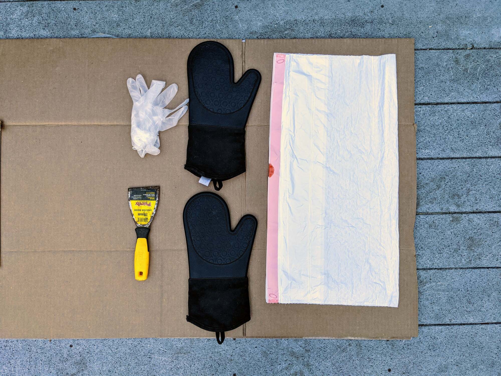 Tools for cleaning a grill set on flattened cardboard.