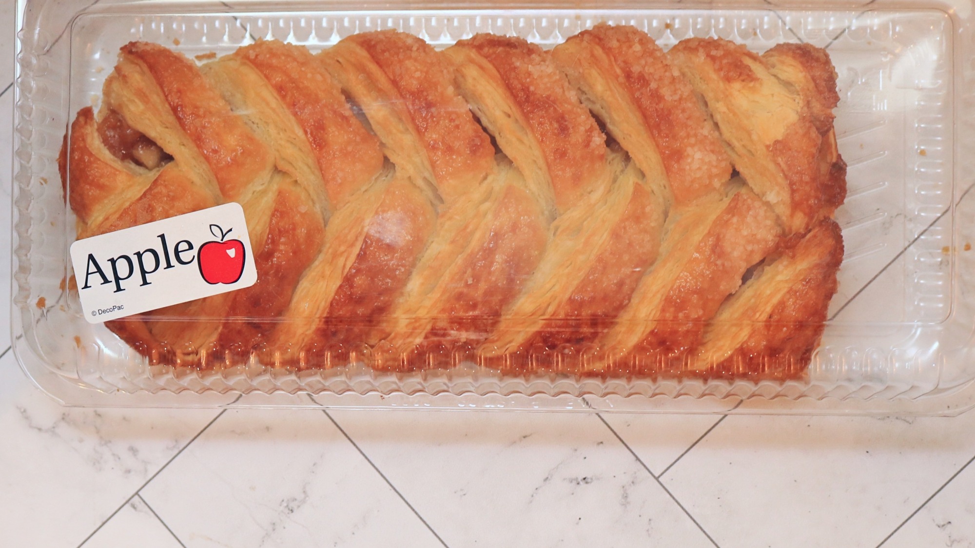 An apple strip pastry in a plastic container from the store.