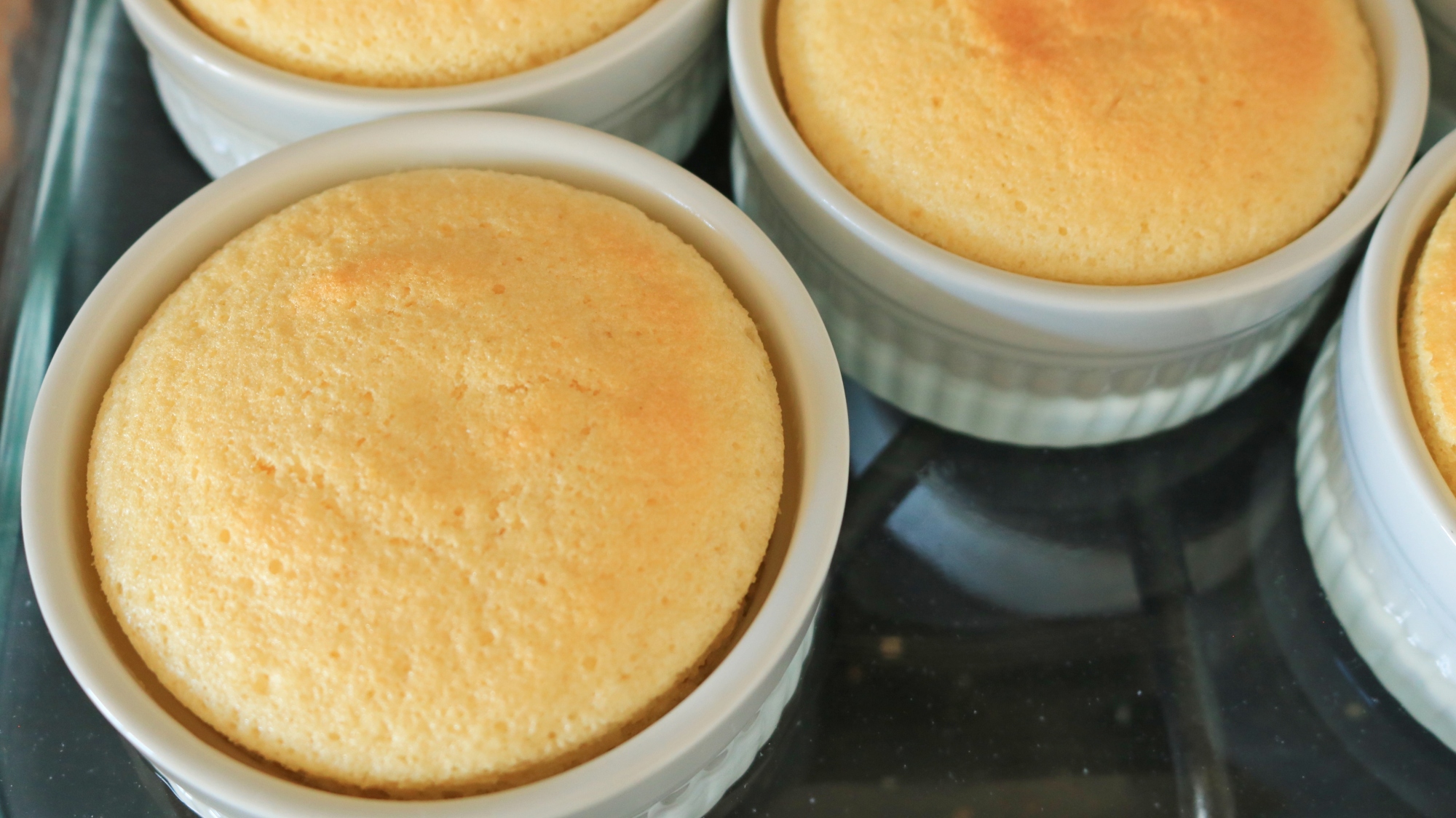 Ramekins of yellow cake in a dish close up.