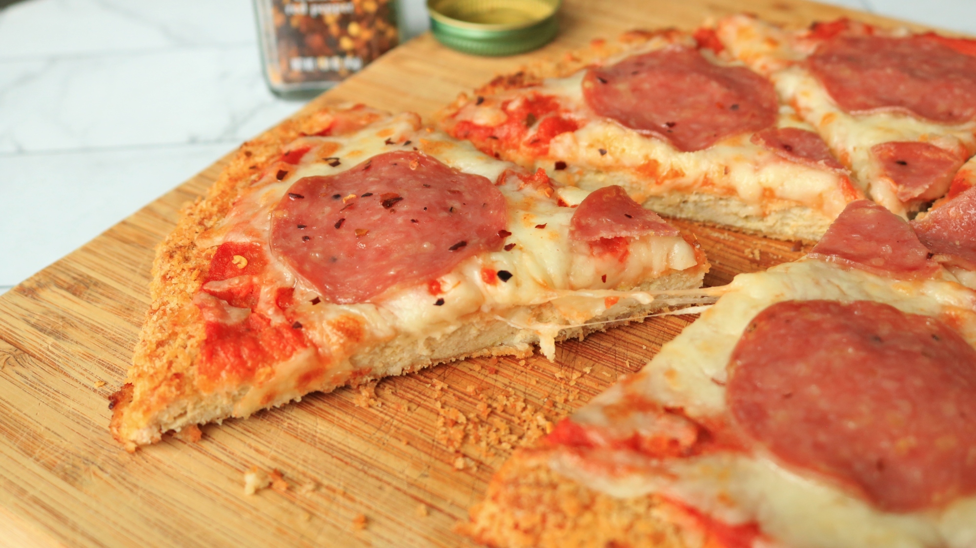 Chicken crust pizza on a cutting board.